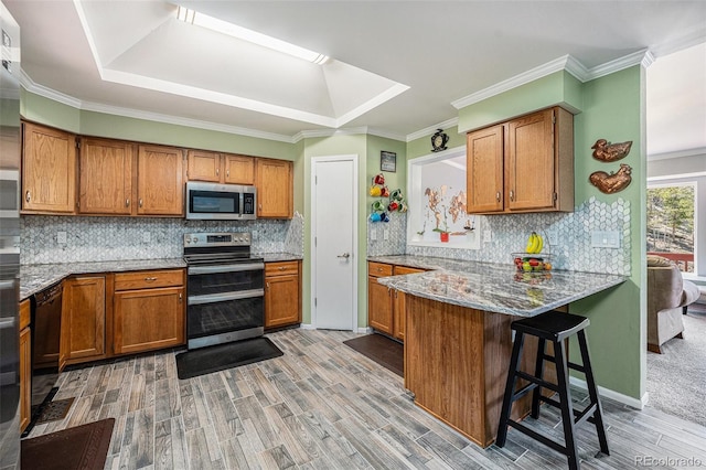 72 Rudi Ln W, Golden, CO 80403 - kitchen featuring stainless steel appliances, brown cabinets, light wood-style floors, and crown molding