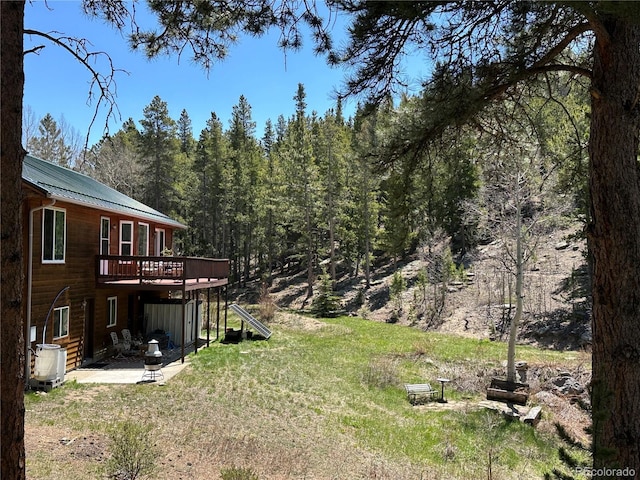 72 Rudi Ln W, Golden, CO 80403 - view of grassy yard featuring a wooden deck, a wooded view, and a patio