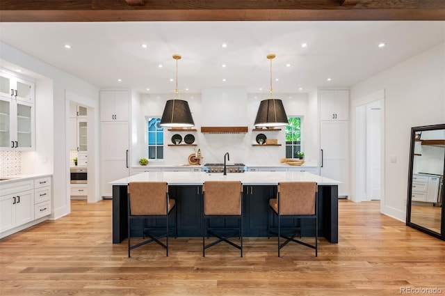 kitchen featuring a large island, decorative backsplash, and light hardwood / wood-style flooring