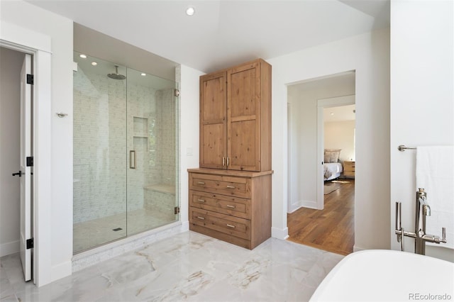 bathroom with shower with separate bathtub and hardwood / wood-style flooring