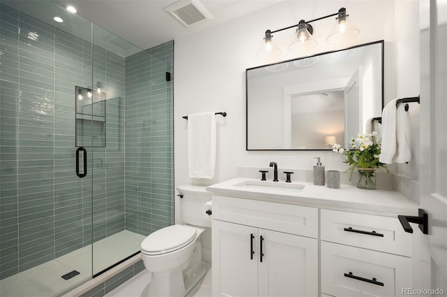 bathroom with walk in shower, vanity, and toilet