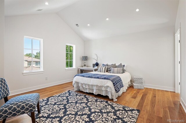 bedroom with hardwood / wood-style flooring and high vaulted ceiling