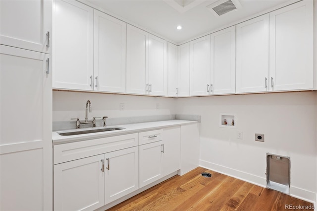 laundry room featuring light hardwood / wood-style floors, washer hookup, electric dryer hookup, cabinets, and sink