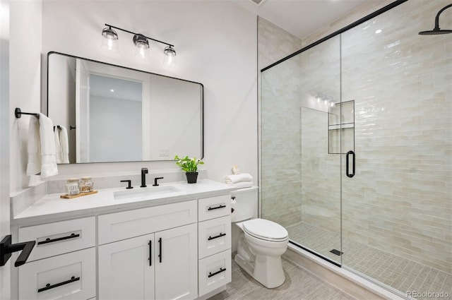 bathroom with an enclosed shower, vanity, and toilet