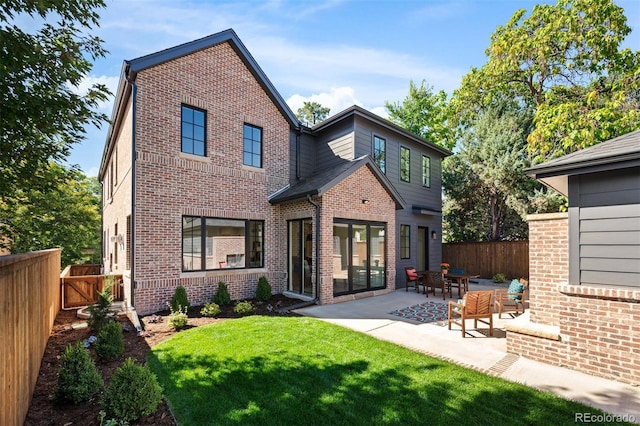 rear view of property featuring a patio and a yard