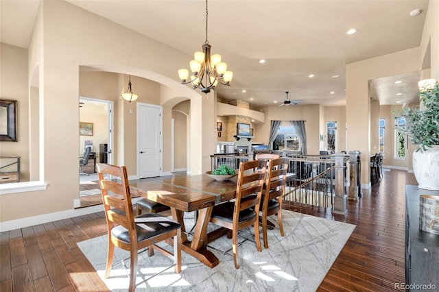 dining room with hardwood / wood-style floors, recessed lighting, arched walkways, and baseboards