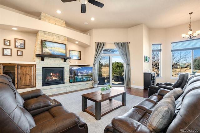 living room with wood finished floors, baseboards, a fireplace, recessed lighting, and ceiling fan with notable chandelier