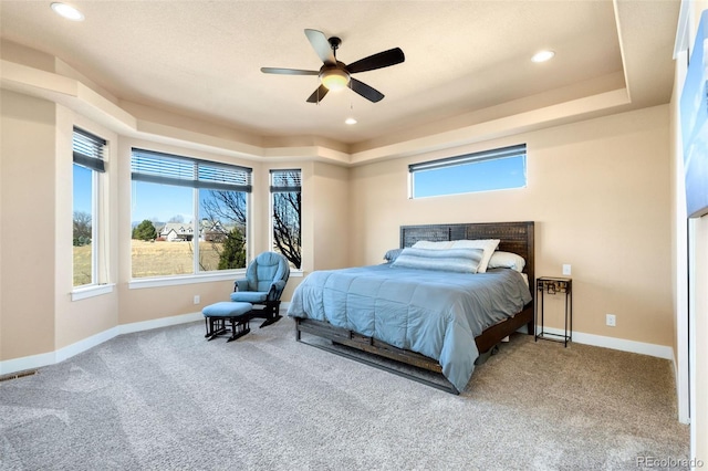 bedroom featuring visible vents, carpet, baseboards, and a raised ceiling