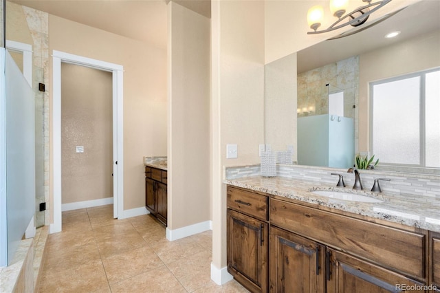 full bath featuring baseboards, decorative backsplash, a stall shower, a notable chandelier, and vanity