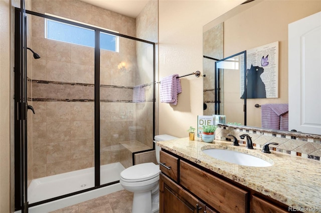 bathroom featuring vanity, a shower stall, and toilet