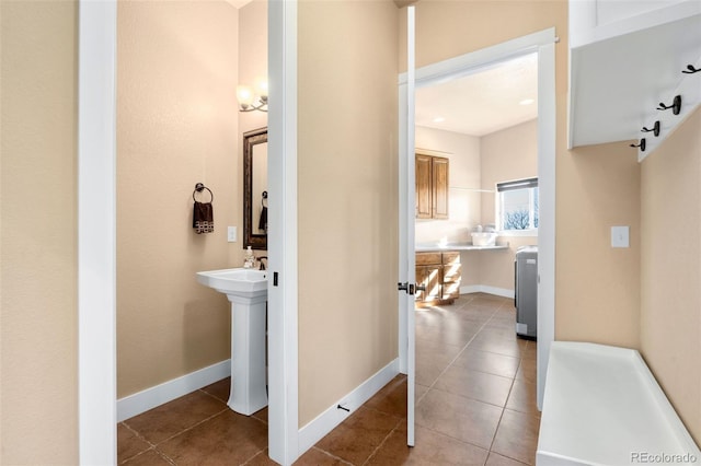 bathroom with a sink, baseboards, and tile patterned flooring