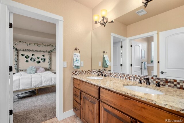 bathroom with a sink, visible vents, backsplash, and ensuite bathroom