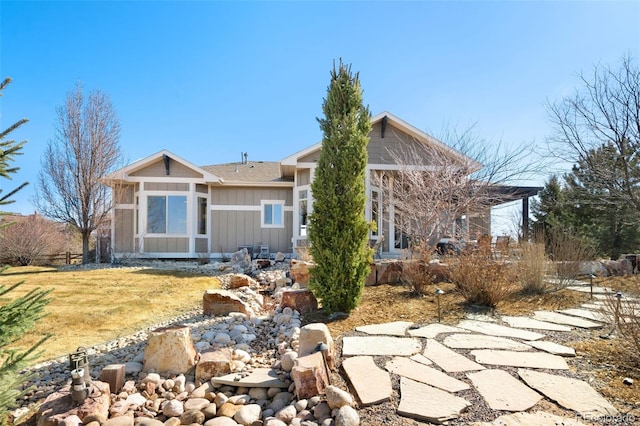 rear view of property with a lawn and board and batten siding