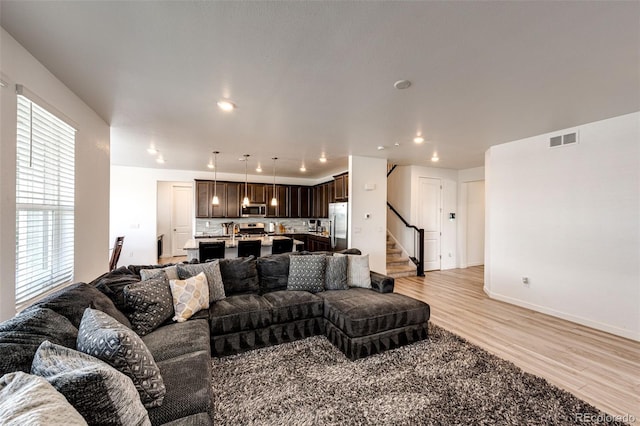 960 S De Gaulle Ct, Aurora, CO 80018 - living room with light wood-style floors, stairs, baseboards, and recessed lighting