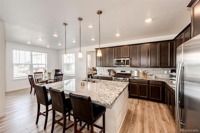 960 S De Gaulle Ct, Aurora, CO 80018 - kitchen featuring appliances with stainless steel finishes, light wood-style floors, a sink, dark brown cabinetry, and recessed lighting