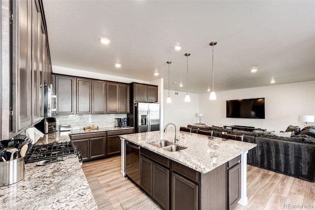 960 S De Gaulle Ct, Aurora, CO 80018 - kitchen with appliances with stainless steel finishes, a sink, dark brown cabinetry, open floor plan, and light wood-type flooring