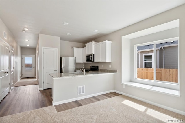 857 Sawdust Dr, Brighton, CO 80601 - kitchen featuring stainless steel appliances, white cabinetry, a sink, dark wood-style flooring, and recessed lighting