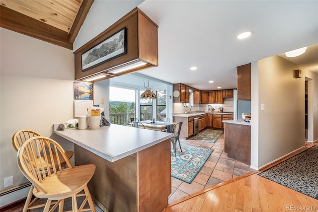 7815 Armadillo Trl, Evergreen, CO 80439 - kitchen with a peninsula, light countertops, recessed lighting, brown cabinets, and dishwasher