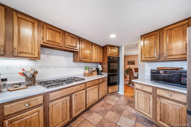 7815 Armadillo Trl, Evergreen, CO 80439 - kitchen with backsplash, stainless steel gas cooktop, light countertops, and dobule oven black