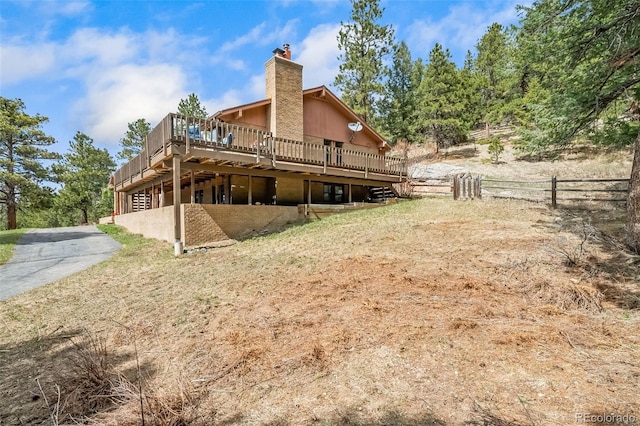7815 Armadillo Trl, Evergreen, CO 80439 - rear view of house with a wooden deck and a chimney