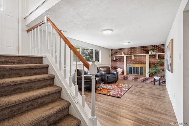 1244 Baron Rd, Colorado Springs, CO 80918 - staircase featuring wood finished floors and a brick fireplace
