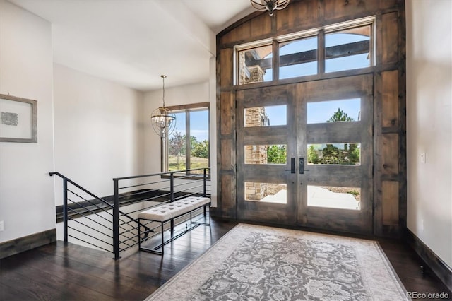 entryway featuring french doors, dark hardwood / wood-style flooring, an inviting chandelier, and lofted ceiling