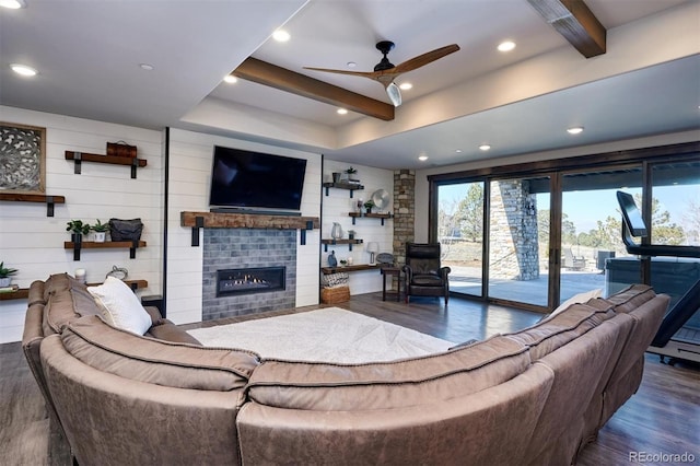 living room featuring ceiling fan, wood walls, beamed ceiling, and dark hardwood / wood-style flooring