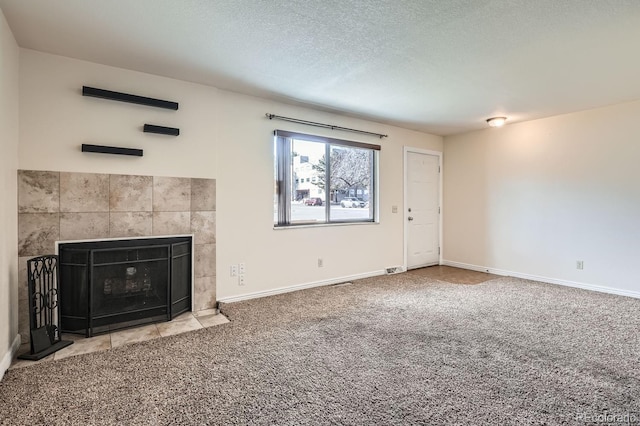 unfurnished living room with a fireplace, carpet flooring, and a textured ceiling