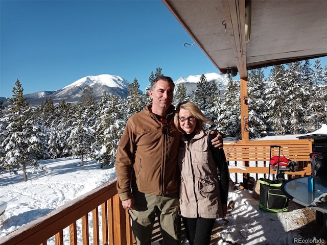 snow covered deck with a mountain view