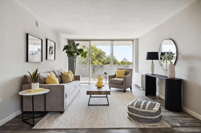 living room with hardwood / wood-style floors, a textured ceiling, and a wall of windows