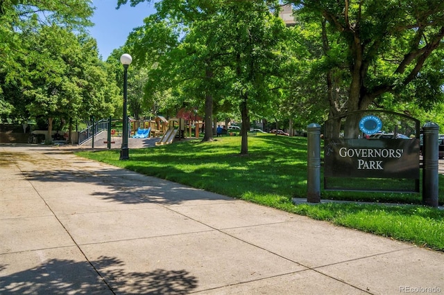 surrounding community with concrete driveway, playground community, and a yard