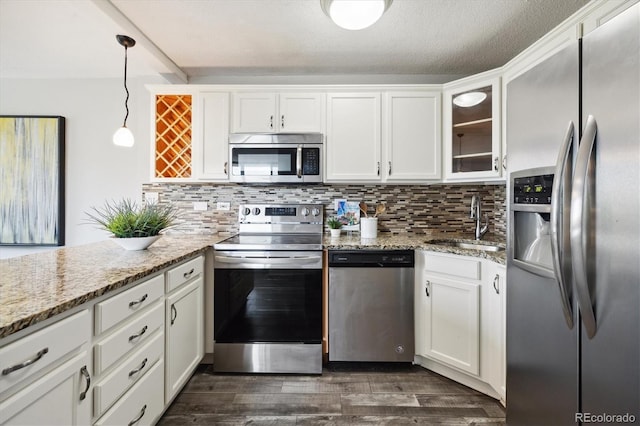 kitchen featuring a sink, stainless steel appliances, backsplash, and dark wood-style floors