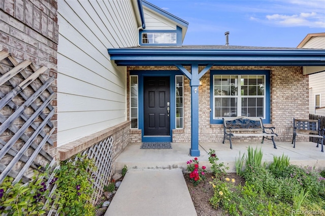 9147 W Rockland Pl, Littleton, CO 80128 - view of exterior entry with a porch and brick siding