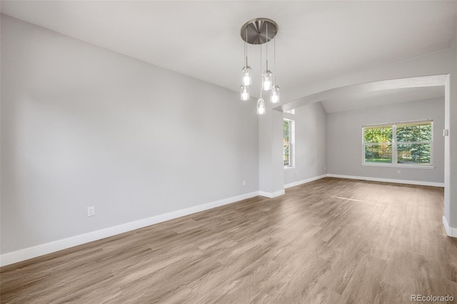 9147 W Rockland Pl, Littleton, CO 80128 - spare room featuring arched walkways, wood finished floors, and lofted ceiling
