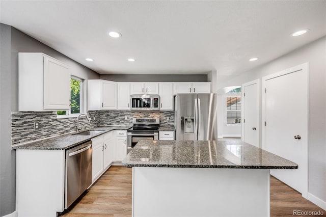 9147 W Rockland Pl, Littleton, CO 80128 - kitchen featuring stainless steel appliances, backsplash, white cabinets, dark stone countertops, and recessed lighting