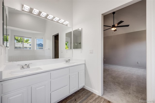 9147 W Rockland Pl, Littleton, CO 80128 - full bath featuring ceiling fan, double vanity, wood finished floors, and a high ceiling