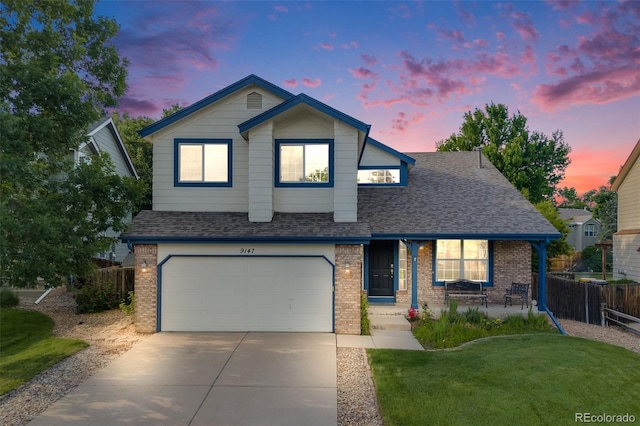 9147 W Rockland Pl, Littleton, CO 80128 - view of front of house featuring brick siding, roof with shingles, a garage, and driveway