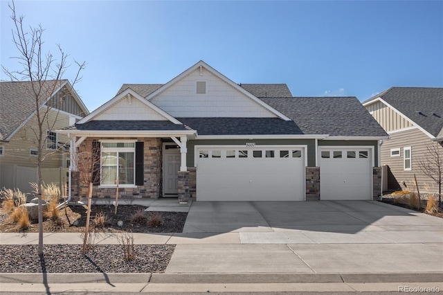 craftsman inspired home featuring stone siding, driveway, roof with shingles, and an attached garage