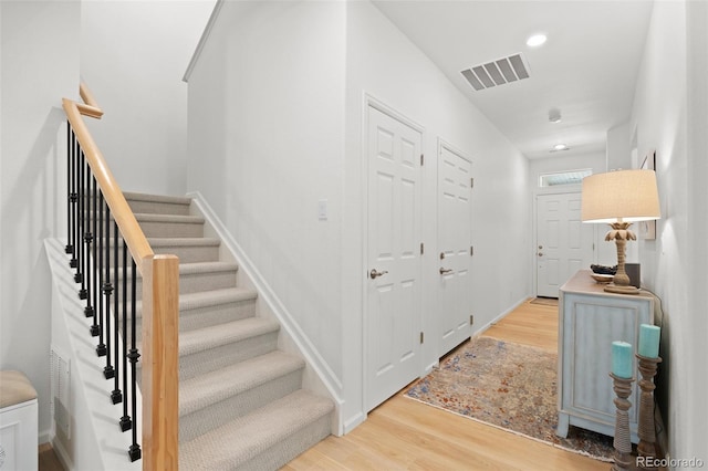 interior space with stairs, recessed lighting, wood finished floors, and visible vents