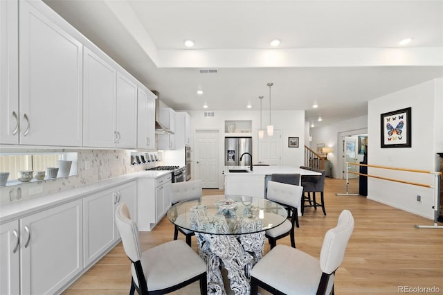 dining space featuring stairway, recessed lighting, light wood-style flooring, and visible vents