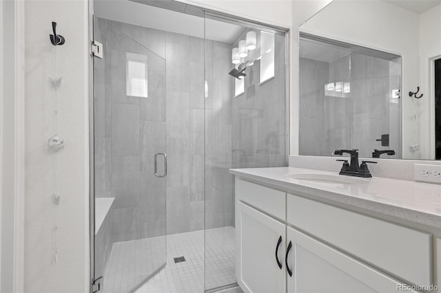 bathroom with a shower stall and vanity