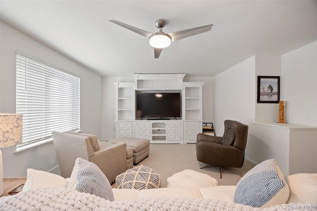 carpeted living area with a ceiling fan