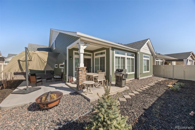 back of house featuring a patio area, a fire pit, and fence