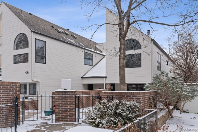 view of snow covered rear of property