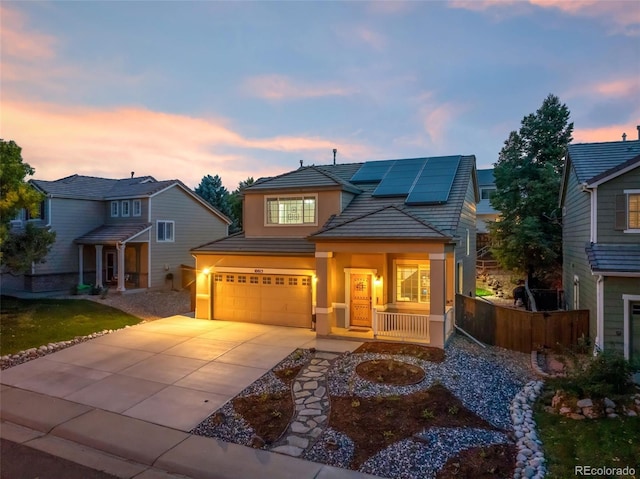 view of front of property featuring stucco siding, a porch, solar panels, concrete driveway, and a garage