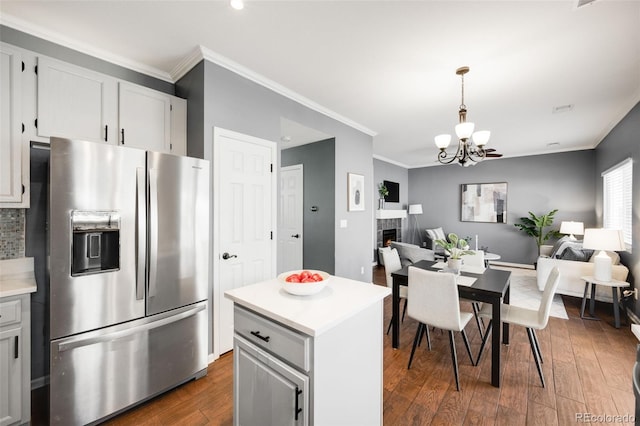 kitchen featuring open floor plan, light countertops, stainless steel refrigerator with ice dispenser, and white cabinetry