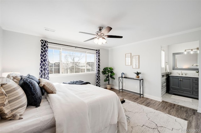 bedroom with ornamental molding, wood finished floors, visible vents, and baseboards