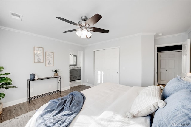 bedroom featuring baseboards, visible vents, ensuite bath, ornamental molding, and light wood-type flooring