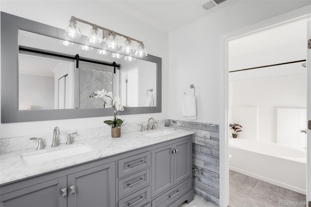 full bath with double vanity, visible vents, a sink, and tile patterned floors