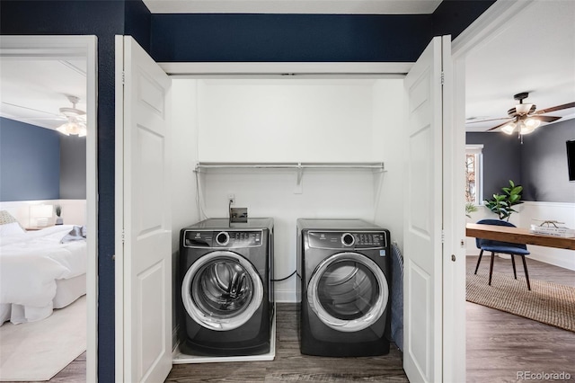 laundry area with dark wood-type flooring, laundry area, washing machine and clothes dryer, and a ceiling fan